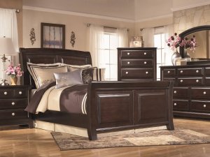 Dark brown wooden furniture set in a bedroom.