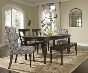 large oval dining table with a complementing mix of solid wood chairs and bench accented with blue upholstered chairs