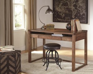 Plain brown wooden desk with leather stool and a black map on the wall.