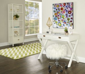 White and modern writing desk with gold nobs and a shaggy stool underneath the desk.