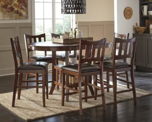Brown oval dining table with brown wooden chairs and a neutral rug underneath.