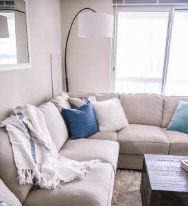 Jenna Colgrove's living room with ashle homestore sofa with ashley homestore pillows and throw blankets.
