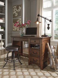The Woodboro traditional looking lift top office desk with Shayneville swivel stool in an office room with flower canvas on the wall and desk lamp on the desk,
