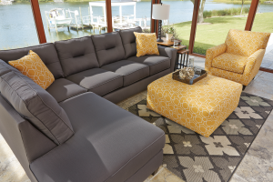 Gray sofa with yello throw pillows and yellow ottoman and chair.