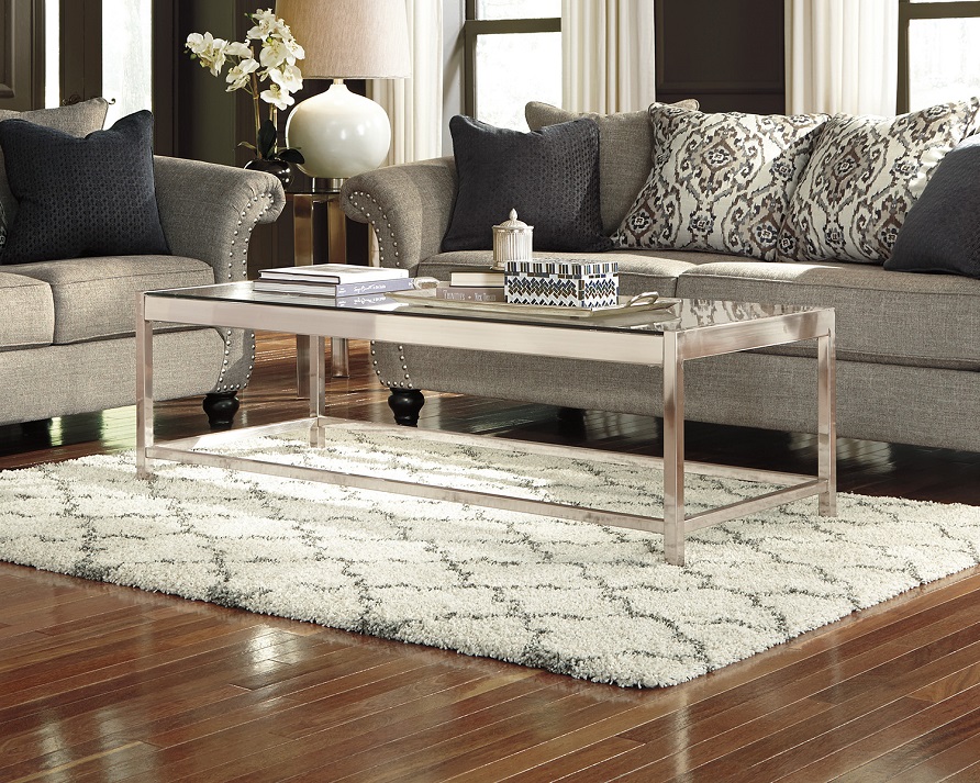 white and gray gate rug underneath a silver coffee table. 