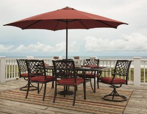 outdoor patio set with brown table and orange cushioned chairs and umbrella
