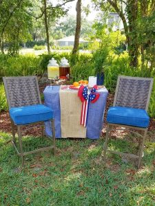 Two ashley outdoor chairs in front of a drink station in the backyard.