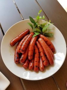 Grilled hot dogs displayed on a serving plate.