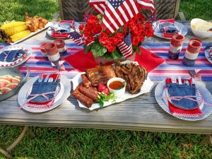 Memorial day dining table set with food from the grill with patriotic theme.