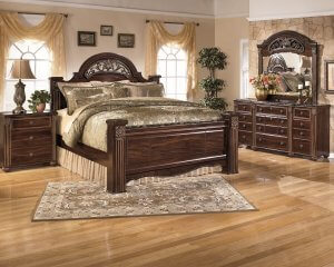 Large brown wooden poster bed with a very old school look.