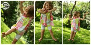 little girl playing on a diy tight rope in her yard.