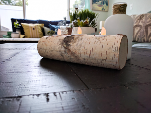 Wood log candle holder with candles inside as decoration for the coffee table.