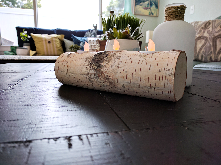 Wood log candle holder with candles inside as decoration for the coffee table. 