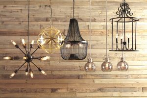 group shot of pendant lights hanging in front of rustic wood paneling.