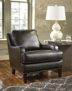 brown leather lounge chair with a side table next to it with a white lamp.