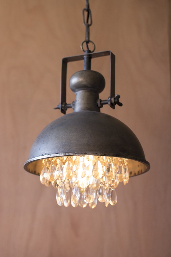Metal pendant lamp with crystals hanging from light.