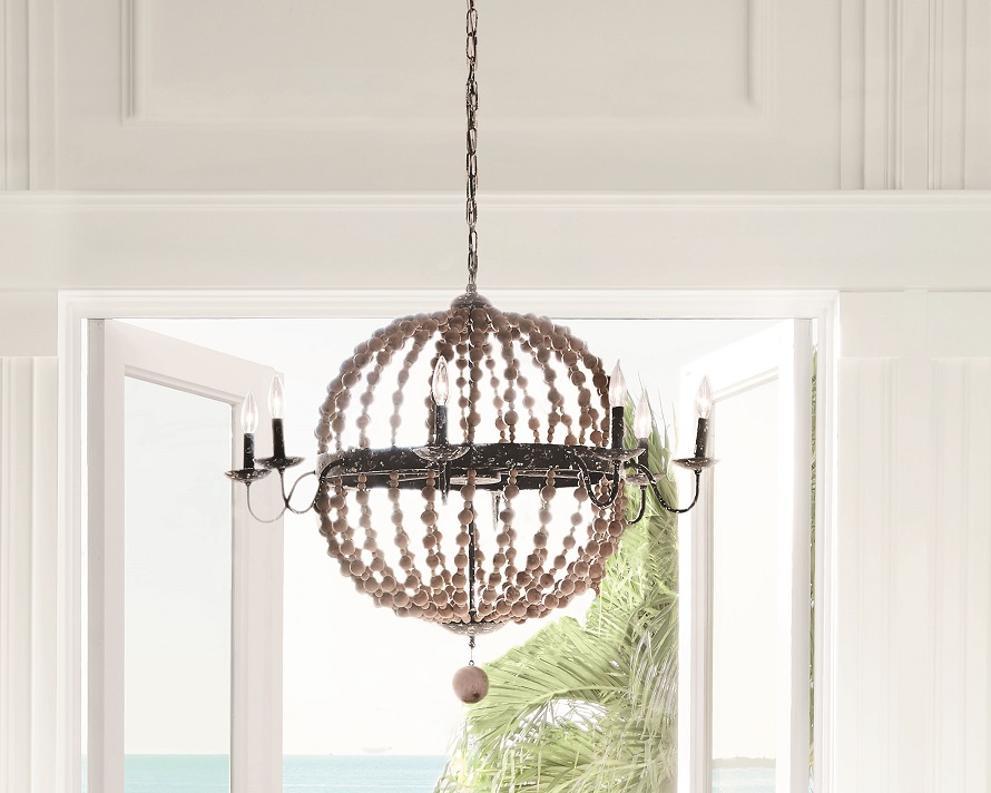 A neutral chic chandelier made of wooden beads hanging from the ceiling.