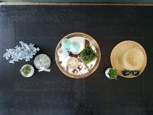 Over head shot of a flat surface with decor accents on top like candles, vases, greenery etc.