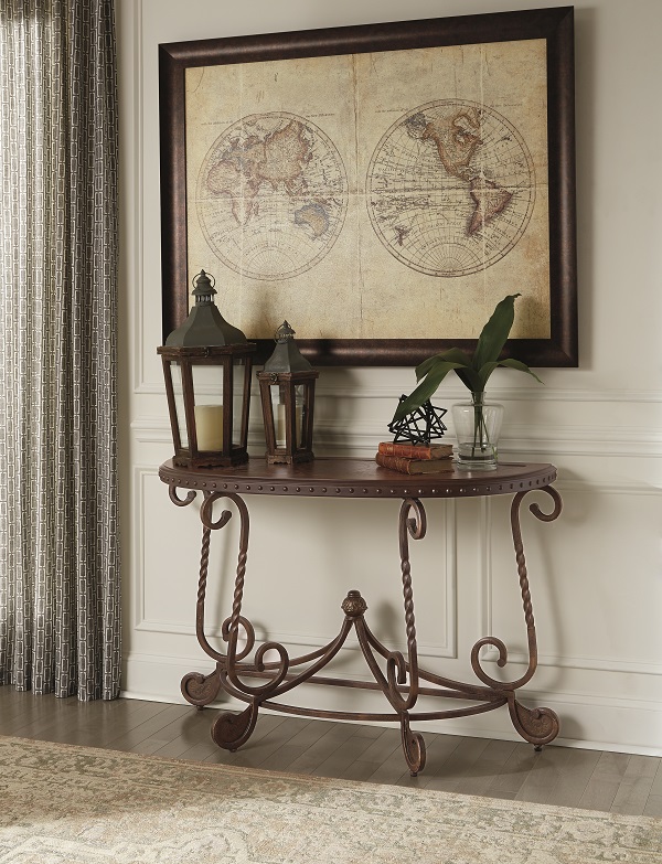 Dark brown wooden console table with global decor on top.