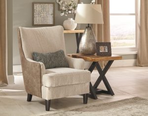 contemporary chair in a neutral room with a side table and lamp next to it.