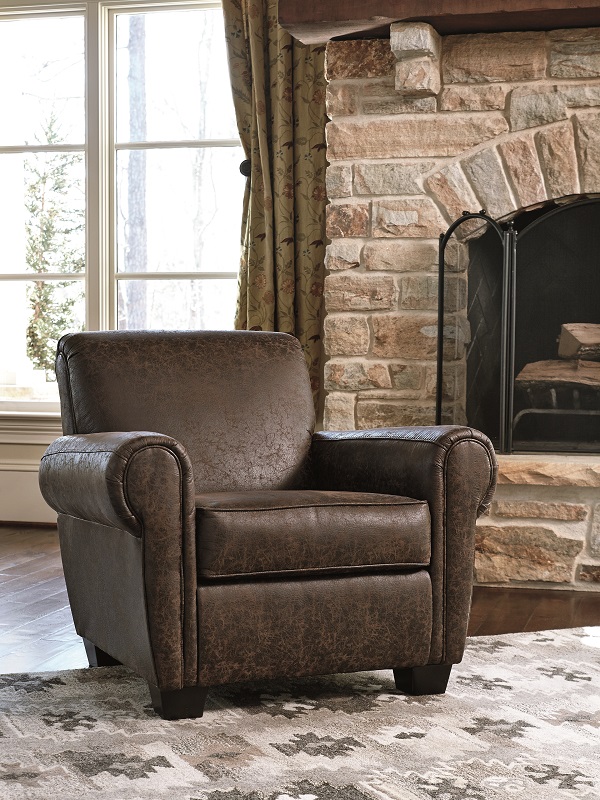 leather like brown chair in front of a fireplace.