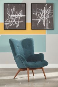 Retro and edgy accent chair in front of a yellow and blue checkered wall with abstract wall art.