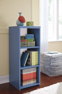 blue youth bedroom bookcase next to a blue and white pouf