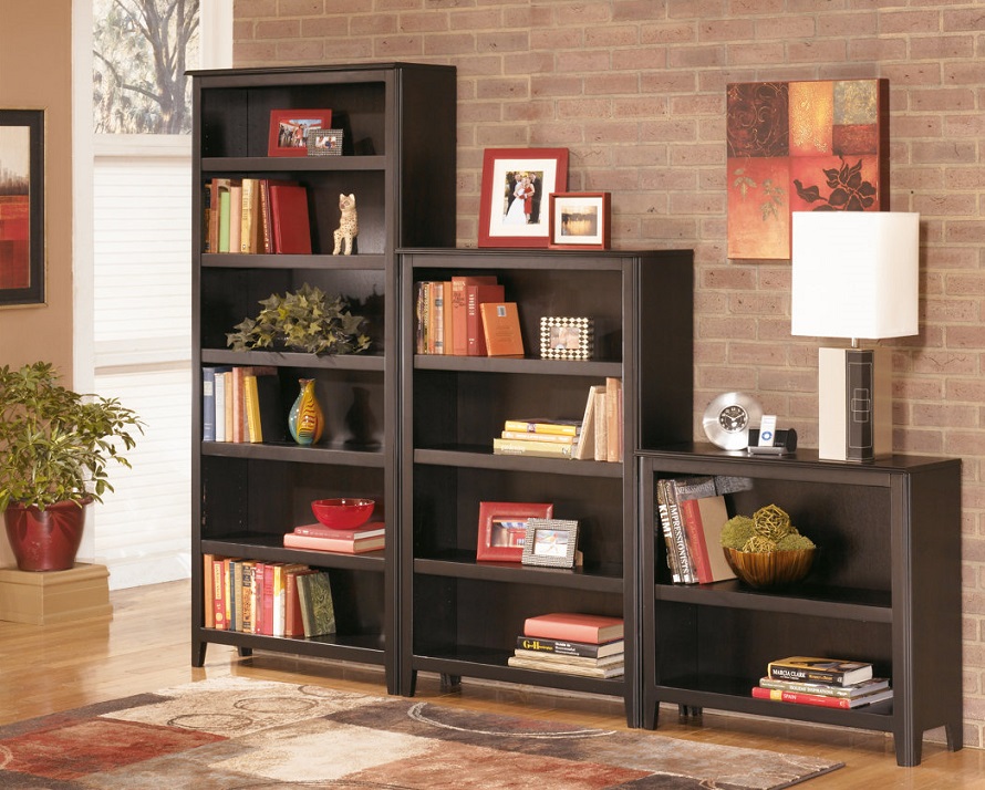 dark brown bookcases with adjustable shelves with books and sculptures organized on the shelves.