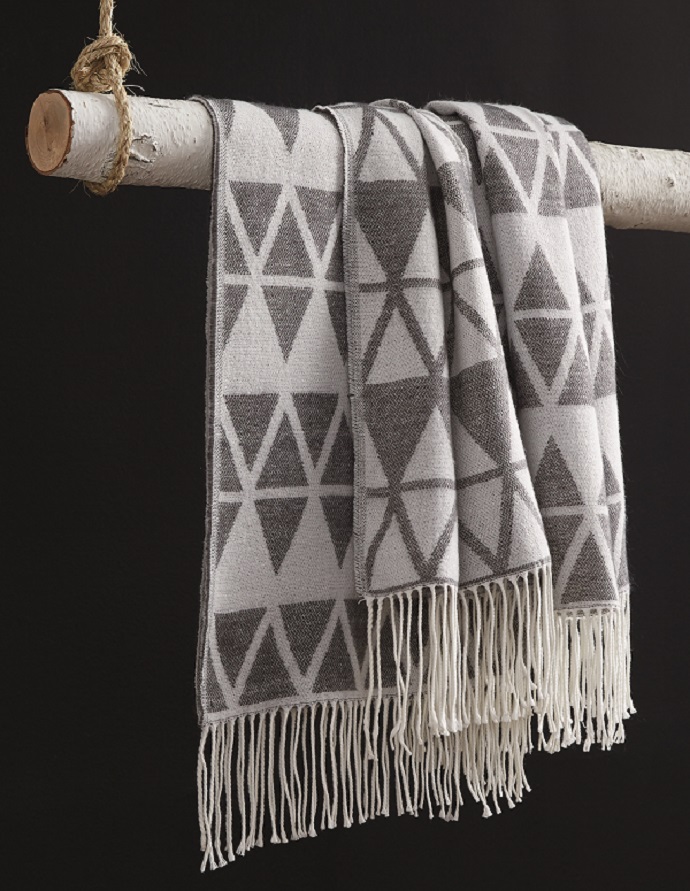 patterned threaded weave blanket with tribal patterns hanging on a tree branch
