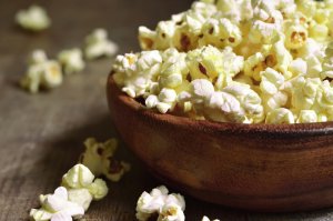 A bowl of popcorn on a wooden table.