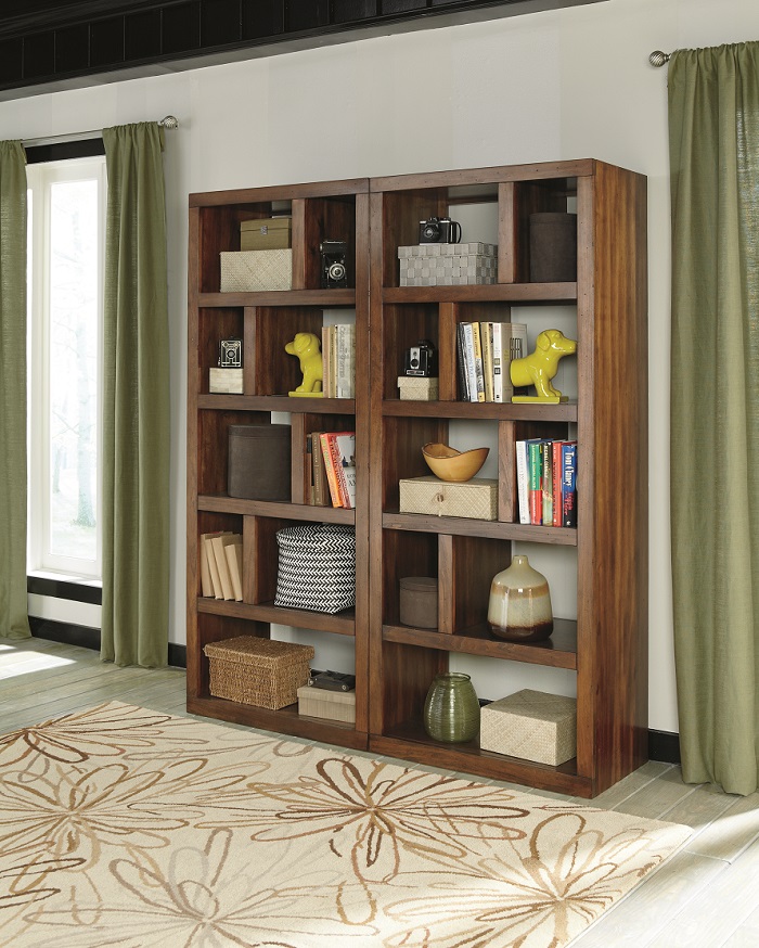 Modern mid-century bookcases with wood finishes standing up next to each other.