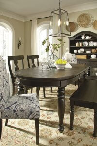 Large dining room with chairs and a bench with a rectangular pendant light hanging above the table.