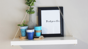 A stencil placed into a frame to display on a wall shelf.