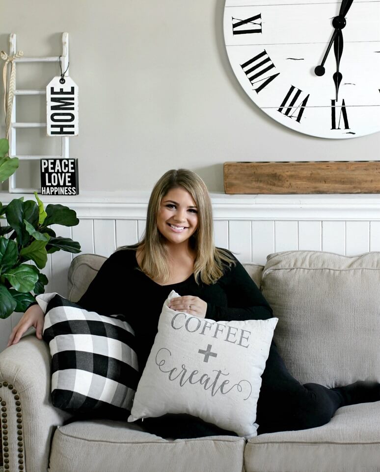 An photograph of jenny caspers on her ashley furniture sofa with a pillow and farmhouse decor surrounding her.