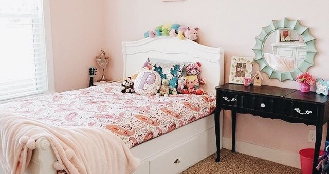 Little girls room with wall decor above the bed.