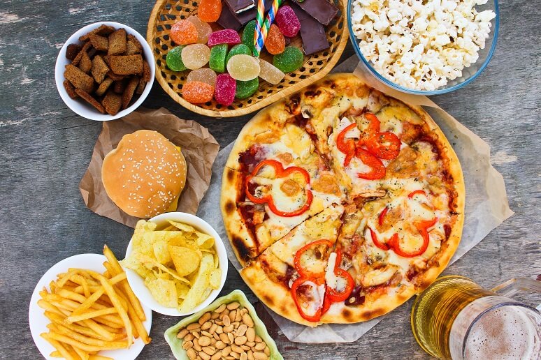 Fast food on old wooden background. Concept of junk eating. Top view.