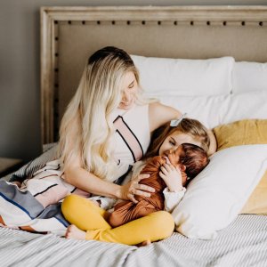 mom in bed with toddler daughter and infant child