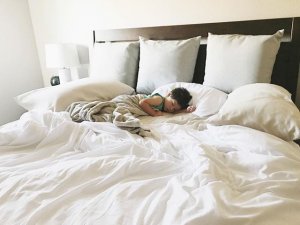 child sleeping in bed with white sheets