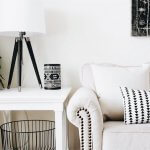 beige couch with white an black pillow next to white nightstand