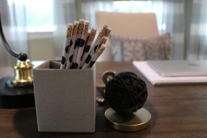 pencils in cup on desk with other decor