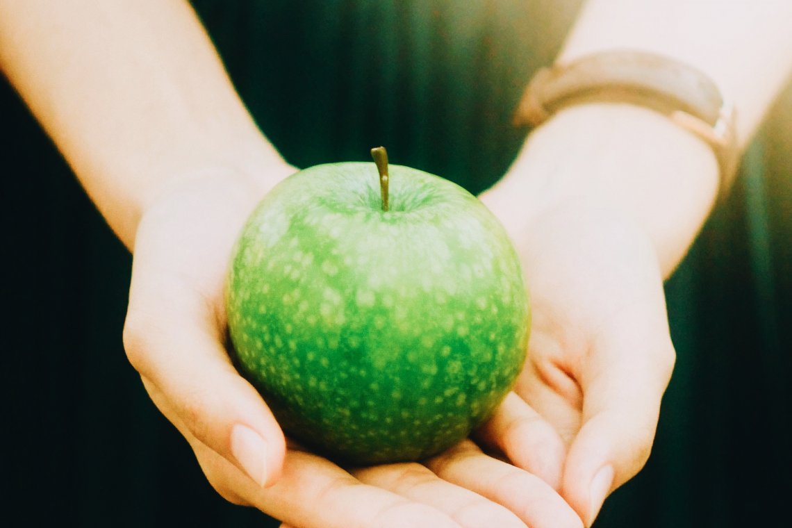 girl holding green apple