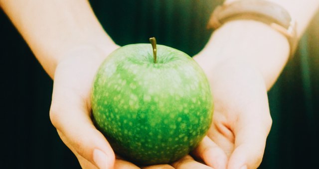 girl holding green apple