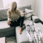 woman sitting on gray couch with coffee