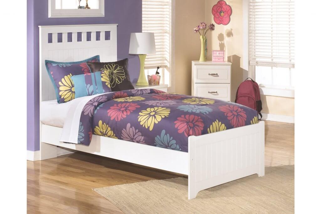 white twin bed with colorful sheets