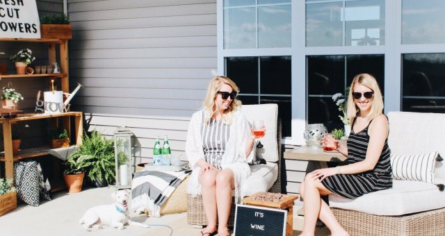 women on outdoor furniture with wine