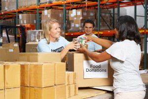 woman donating food to volunteers