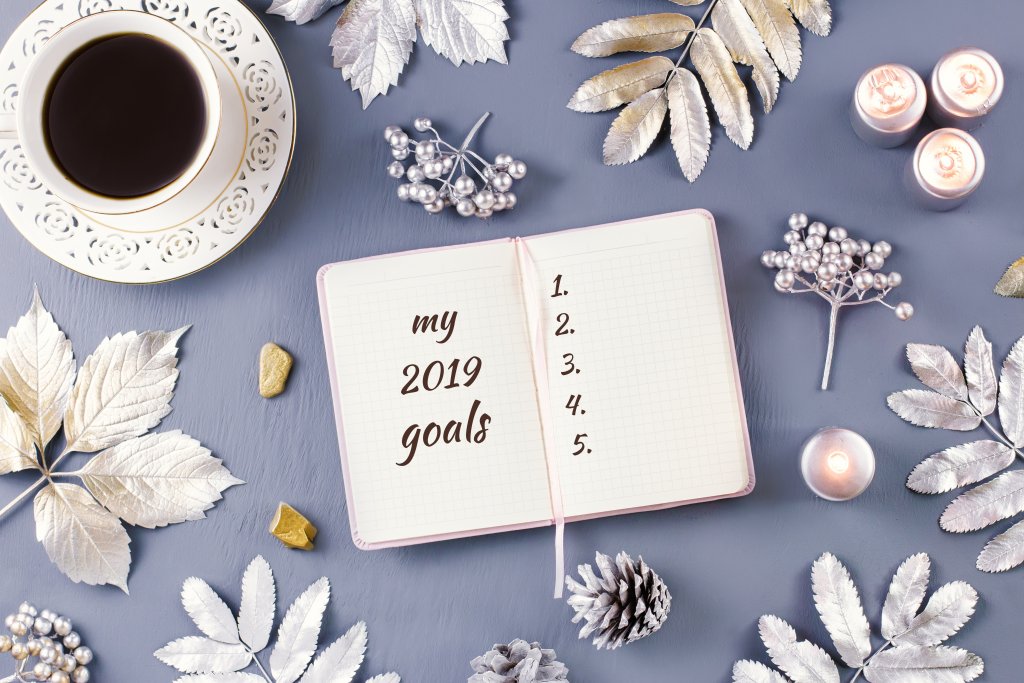 New Year goals list with candles, decor and coffee drink