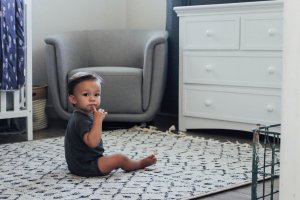 Baby sitting on rug.