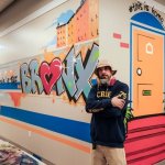 Man poses with mural.