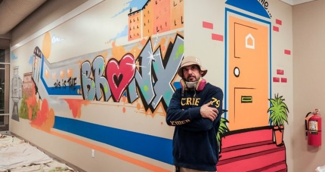 Man poses with mural.